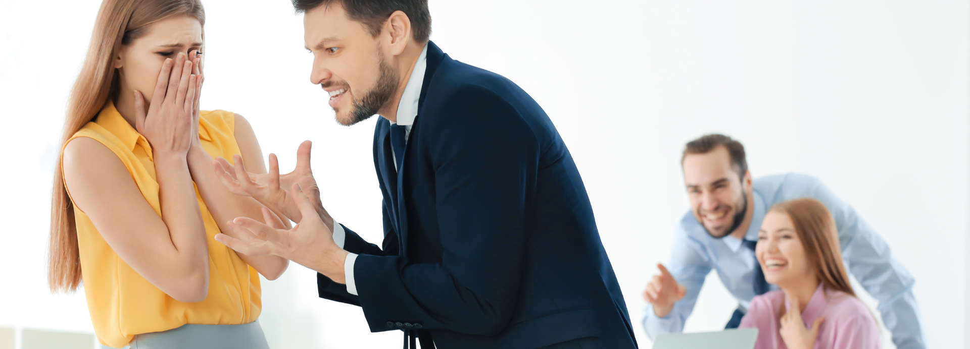 Violent businessman shouting at a scared female office worker and two laughing co-workers in the background