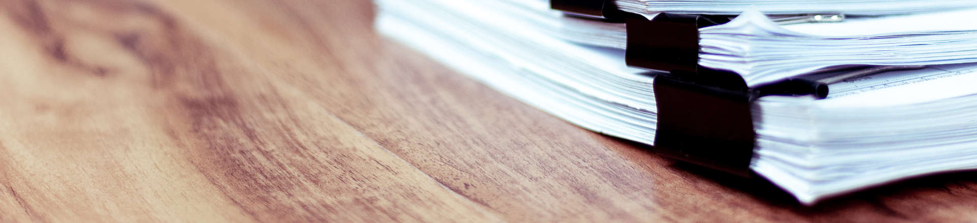 Pile of contract forms on wooden desk