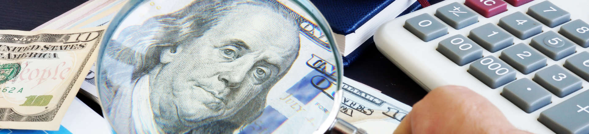 a person using a magnifying to check a banknote