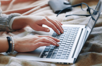 close up of hands typing on the laptop keyboard