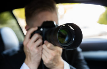 private detective sitting inside car doing surveillance work