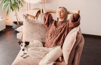 Relaxed satisfied Middle aged Woman Sitting leaning back on Couch in air conditioner Room, Happy Peaceful Mature female with hands behind head resting on Sofa at home, enjoying fresh air, breathing